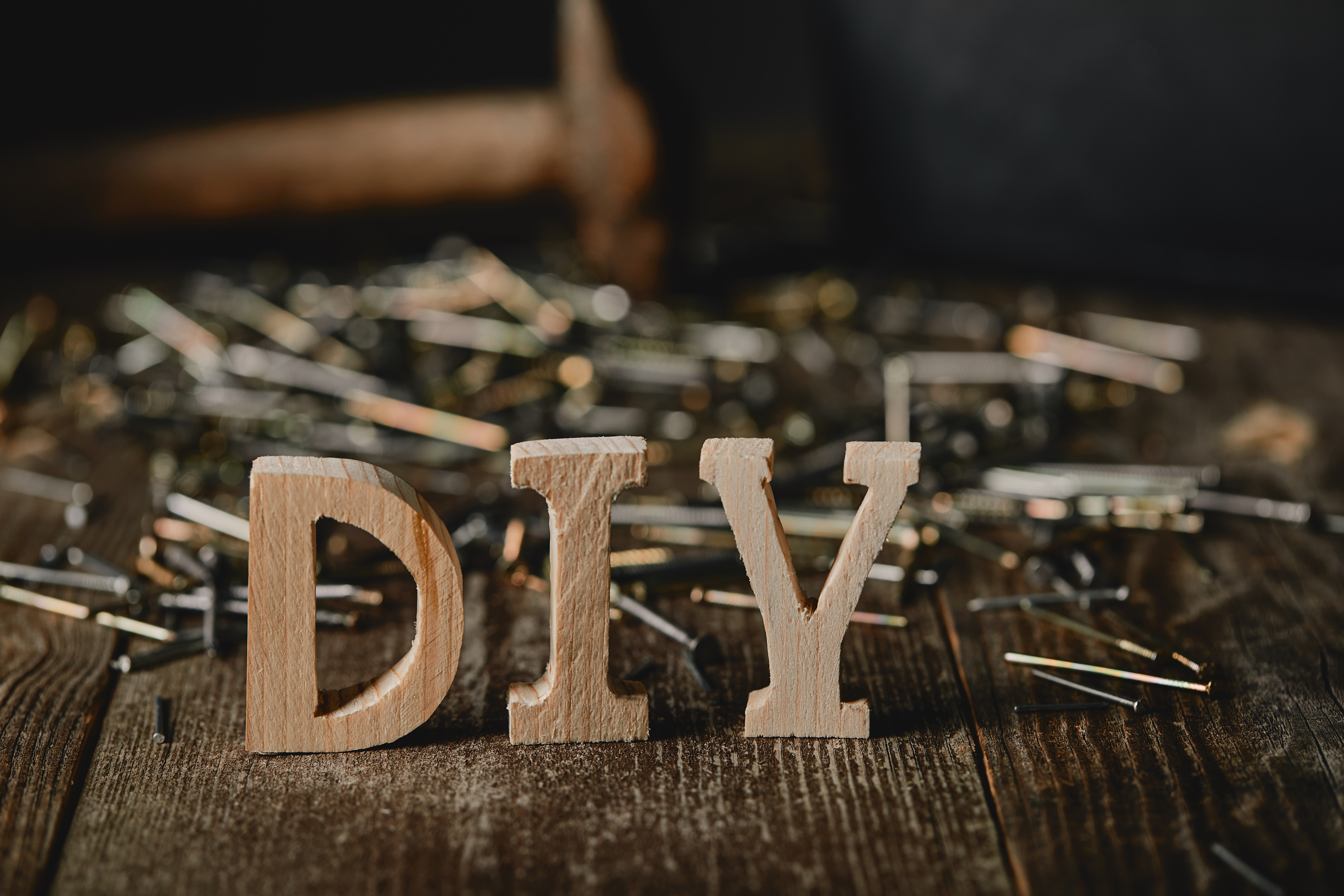 Close up of diy sign on dark wooden table on the background of nails and tools